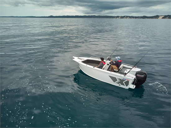 Two people fishing from a white Quintrex Renegade boat on calm open water under a cloudy sky.